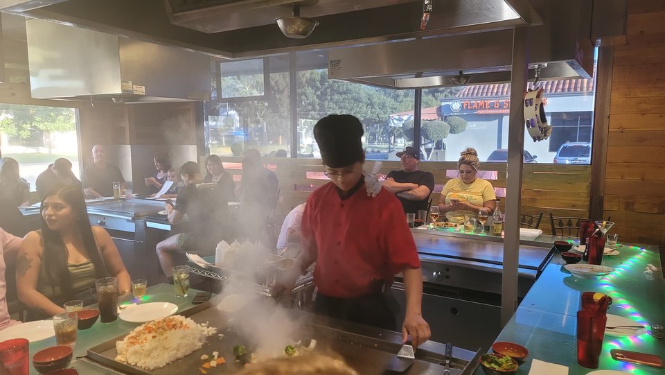 Hibachi grill with a chef cooking at the table.